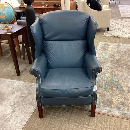Blue leather armchair in a room with furniture and decor.