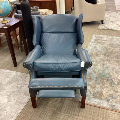 Blue leather recliner chair in a room with furniture and decor.