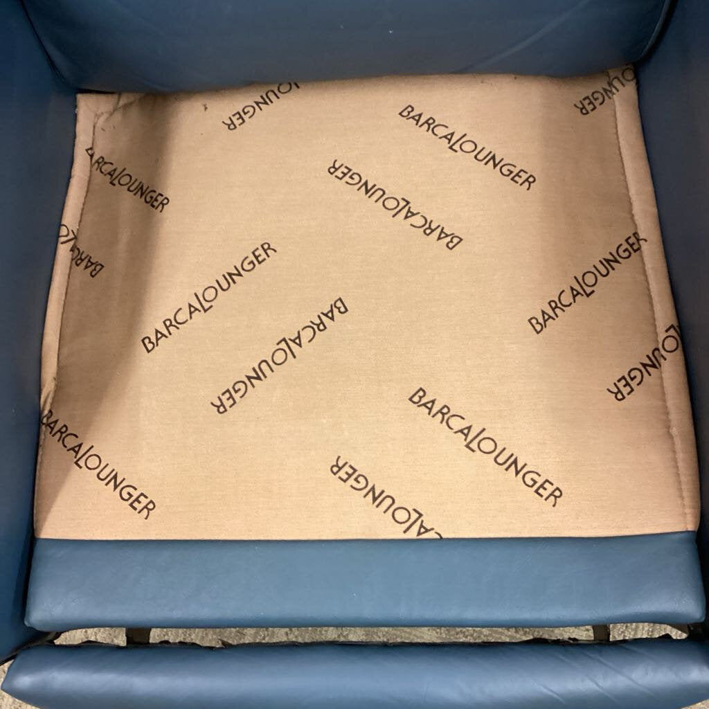 Brown cushion with 'Barcalounger' branding on a blue chair.