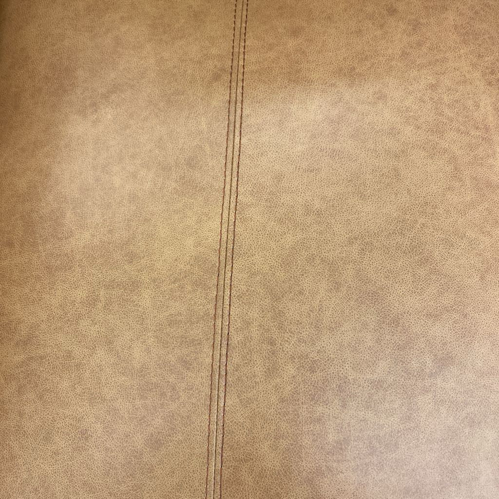 Close-up of beige leather texture with a seam running vertically.