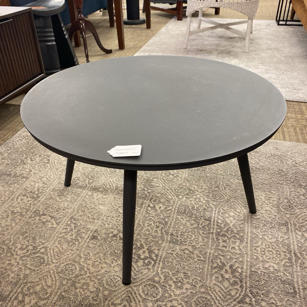 Round black table on a patterned rug in an indoor setting