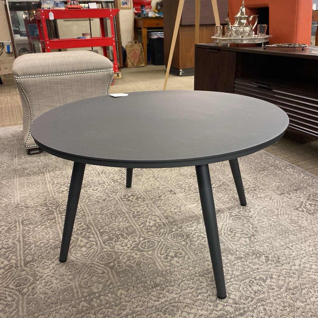 Round black table in a room with furniture and decor