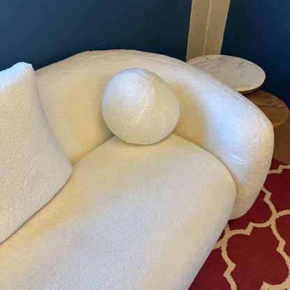 White textured sofa with a red patterned rug underneath