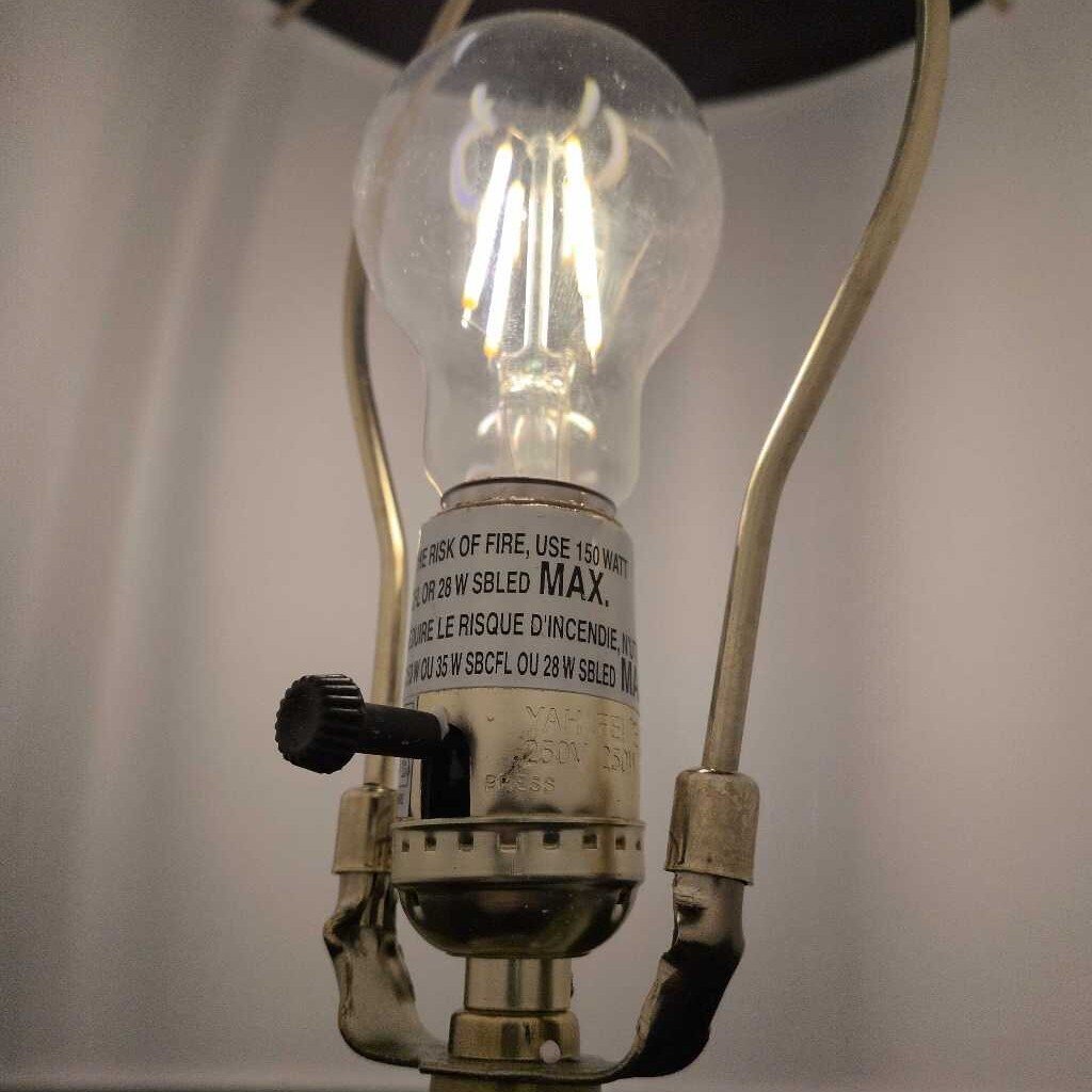 Vintage-style light bulb with visible filament against a neutral background