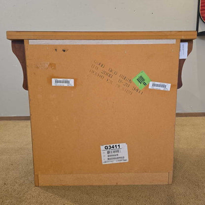 Back of a wooden cabinet with shipping labels on a carpeted floor