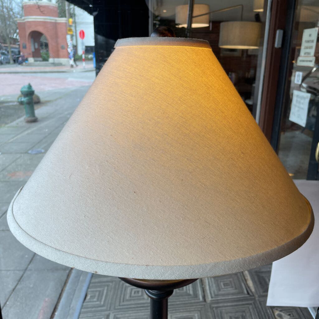Beige lampshade on a stand with a city street background