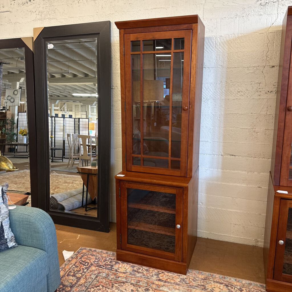 Wooden corner cabinet with glass doors in a room setting