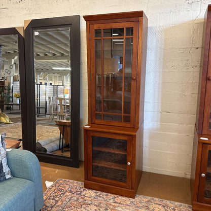 Wooden corner cabinet with glass doors in a room setting