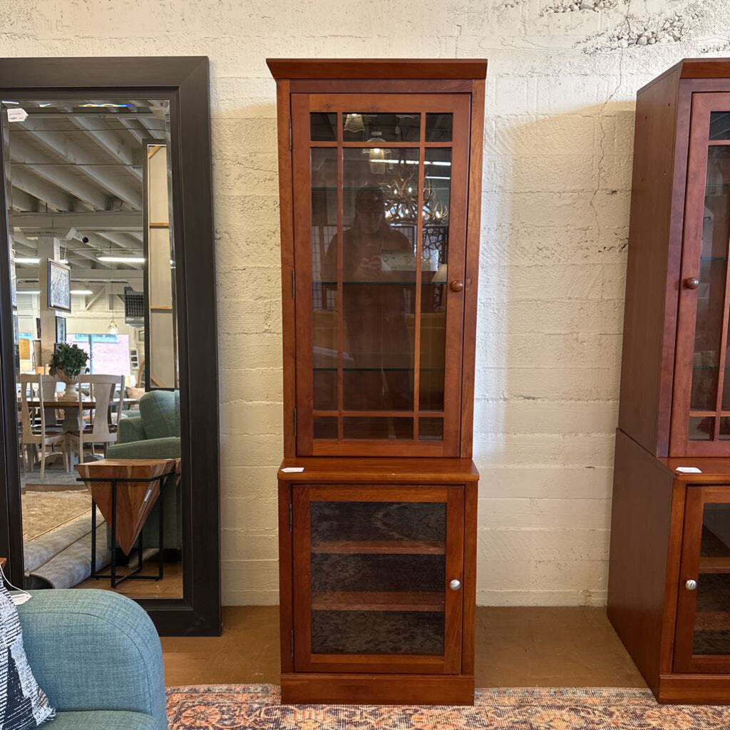 Wooden corner cabinet with glass doors in a room setting