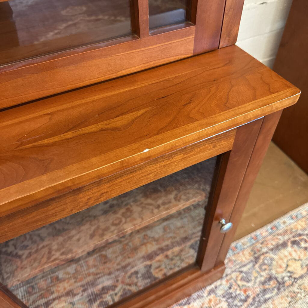 Wooden cabinet with glass panels on a patterned rug