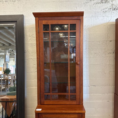 Wooden cabinet with glass doors in a room setting