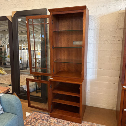 Wooden display cabinet with glass doors in a showroom setting
