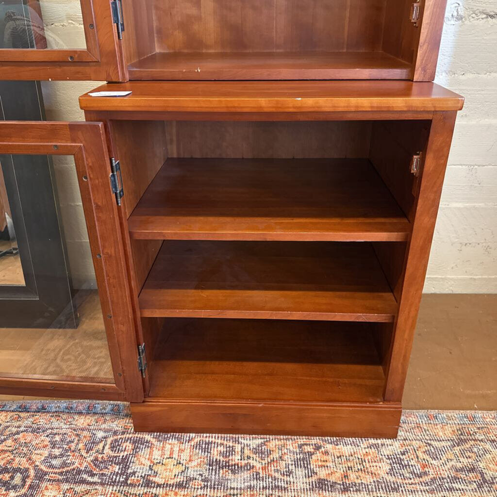 Wooden cabinet with open doors on a patterned rug