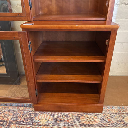 Wooden cabinet with open doors on a patterned rug