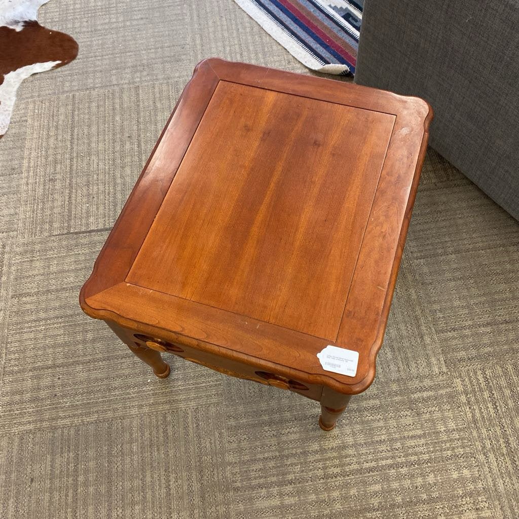 Wooden side table on a carpeted floor with a price tag attached