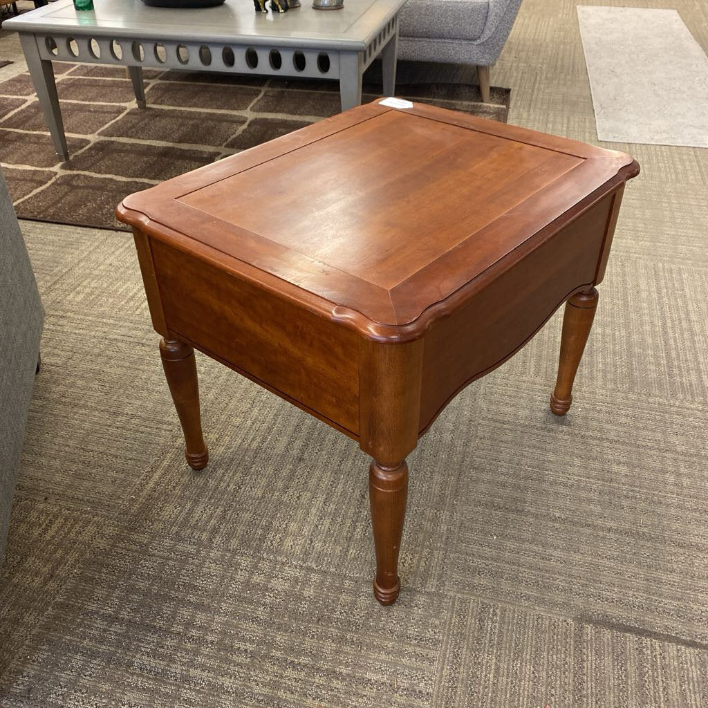 Wooden side table on a carpeted floor