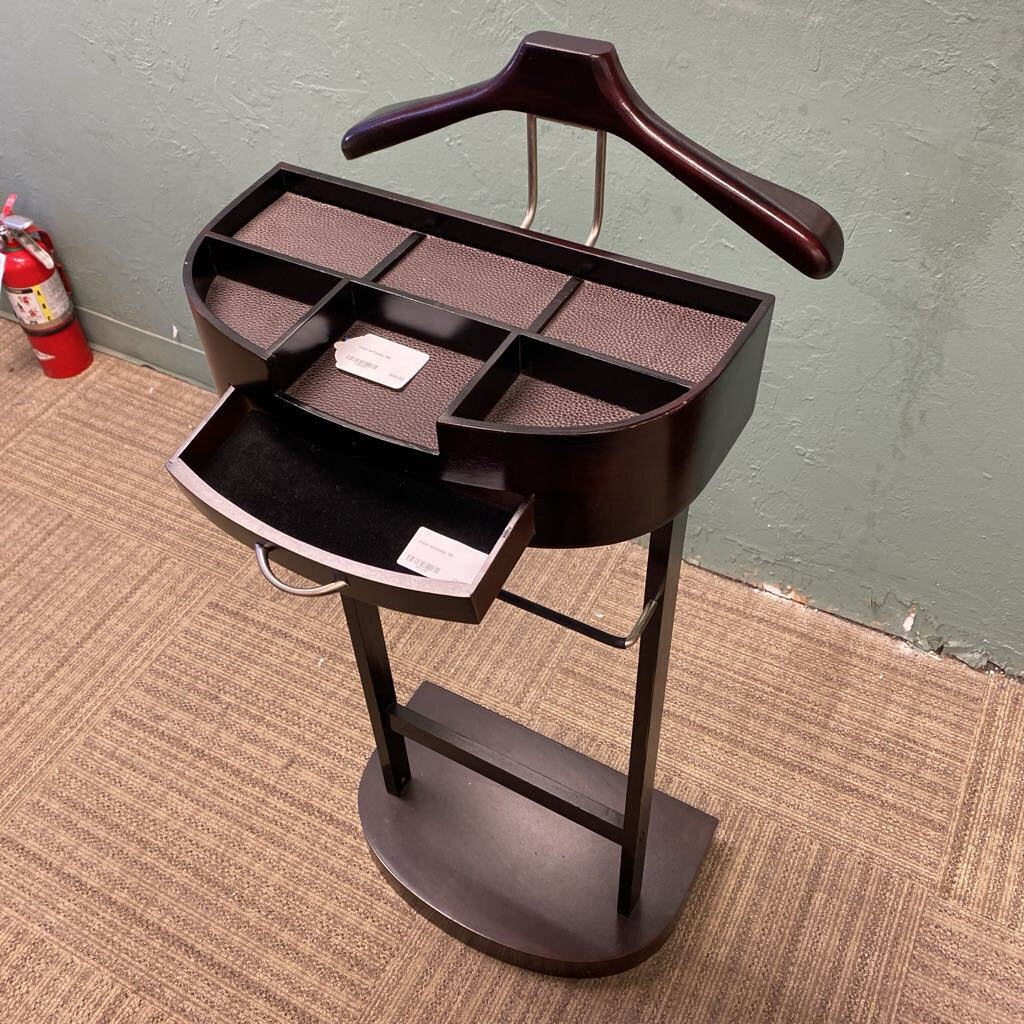 Dark wood grooming table with hanger and compartments on a carpeted floor.