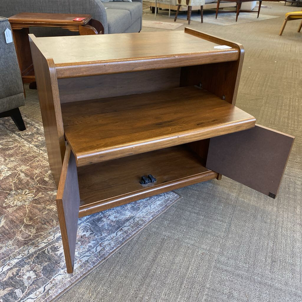 Wooden shelf with open doors on a carpeted floor