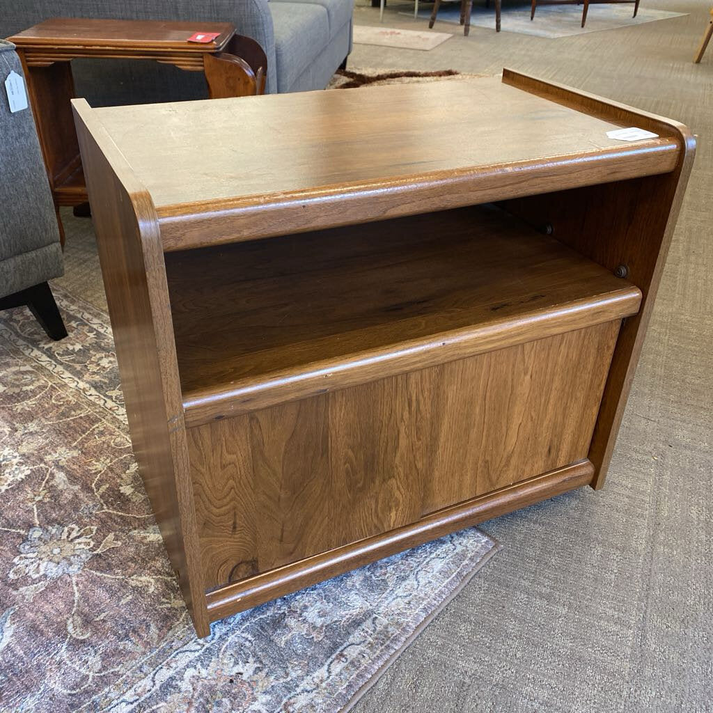 Wooden side table in a room with furniture and carpet