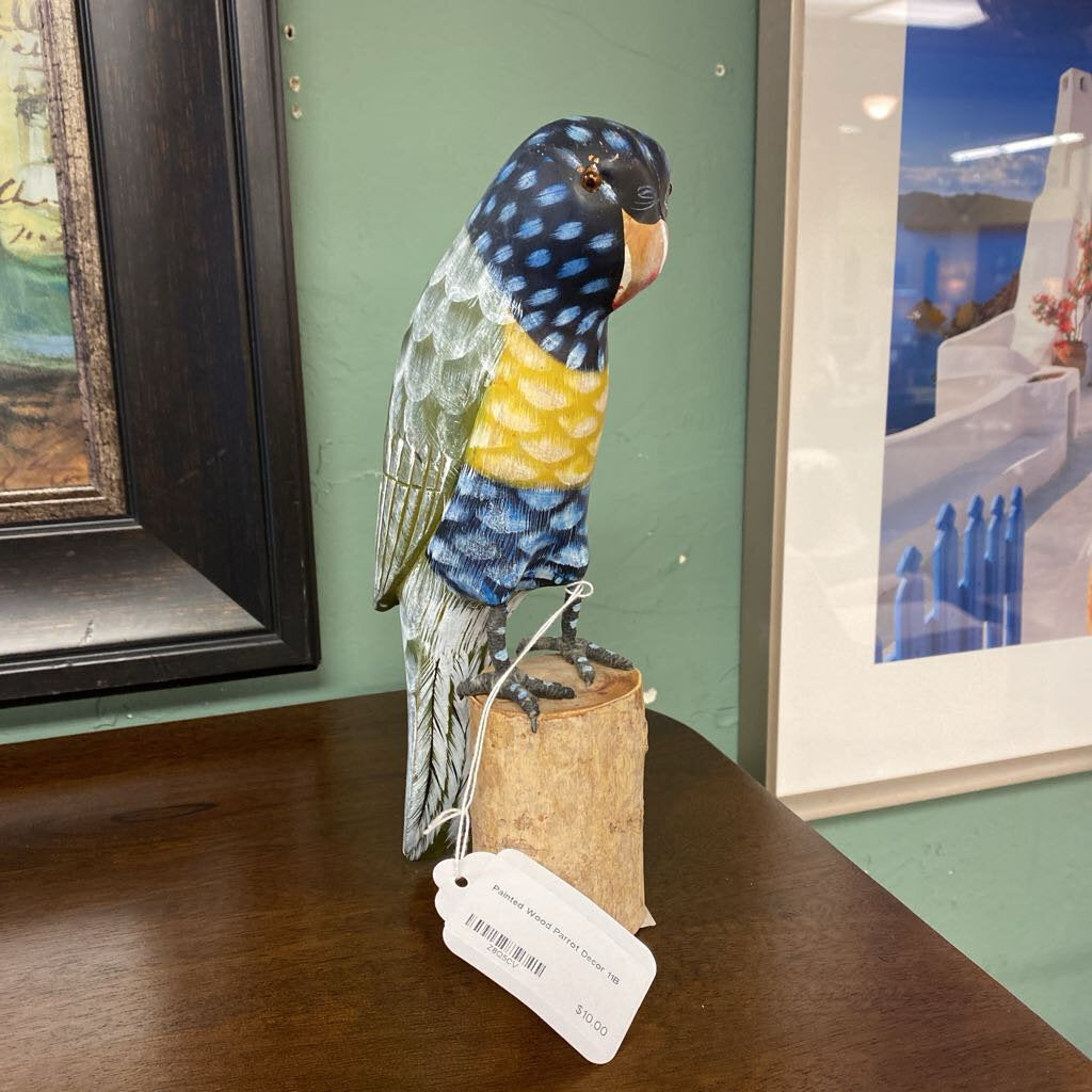 Decorative parrot sculpture on a cork base with a tag, placed on a wooden surface.