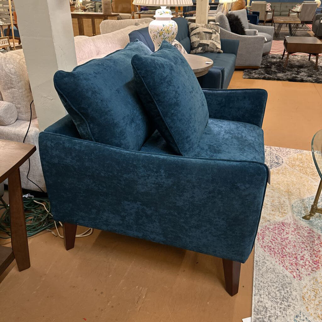 Blue armchair in a showroom with other furniture around