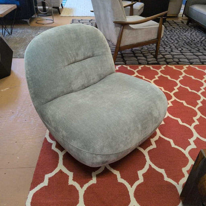 Gray chair on a red and white patterned rug with a blurred background