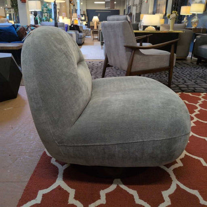 Gray armchair in a showroom with other furniture and decor items.