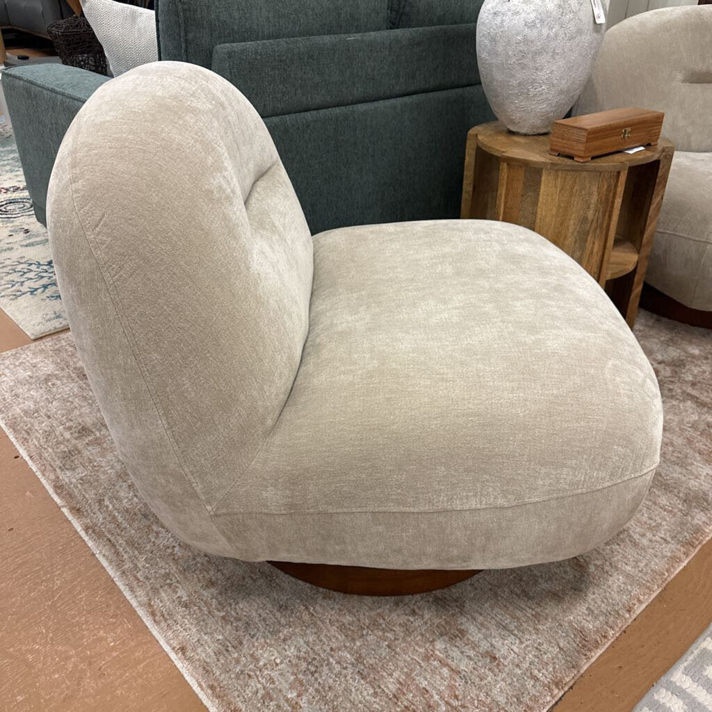 Beige armchair in a room with a wooden side table and gray sofa.