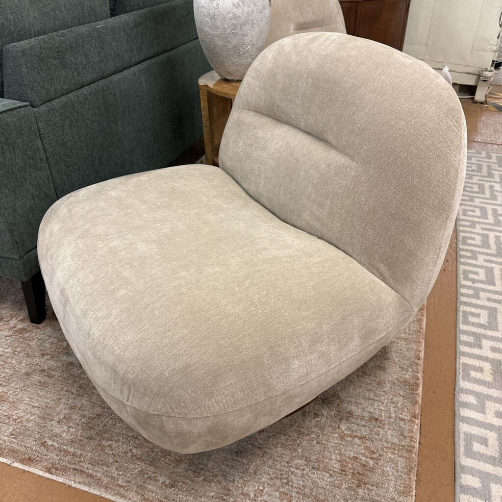Beige armchair in a room with a patterned rug and furniture.