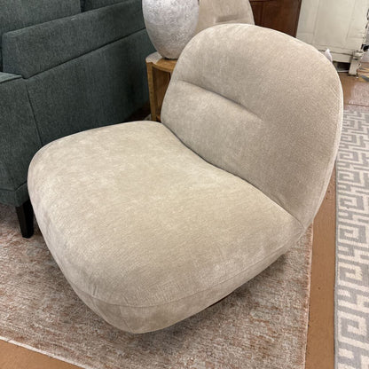 Beige armchair in a room with a patterned rug and furniture.