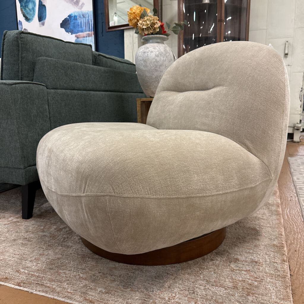 Beige armchair in a living room setting with a gray sofa and decorative elements.