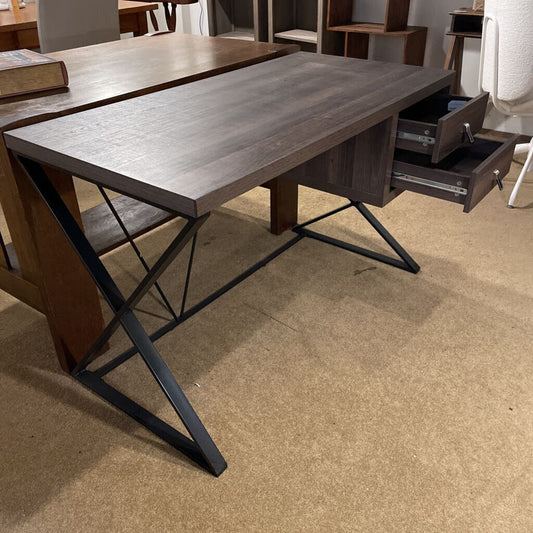 Wooden desk with metal legs on a beige floor