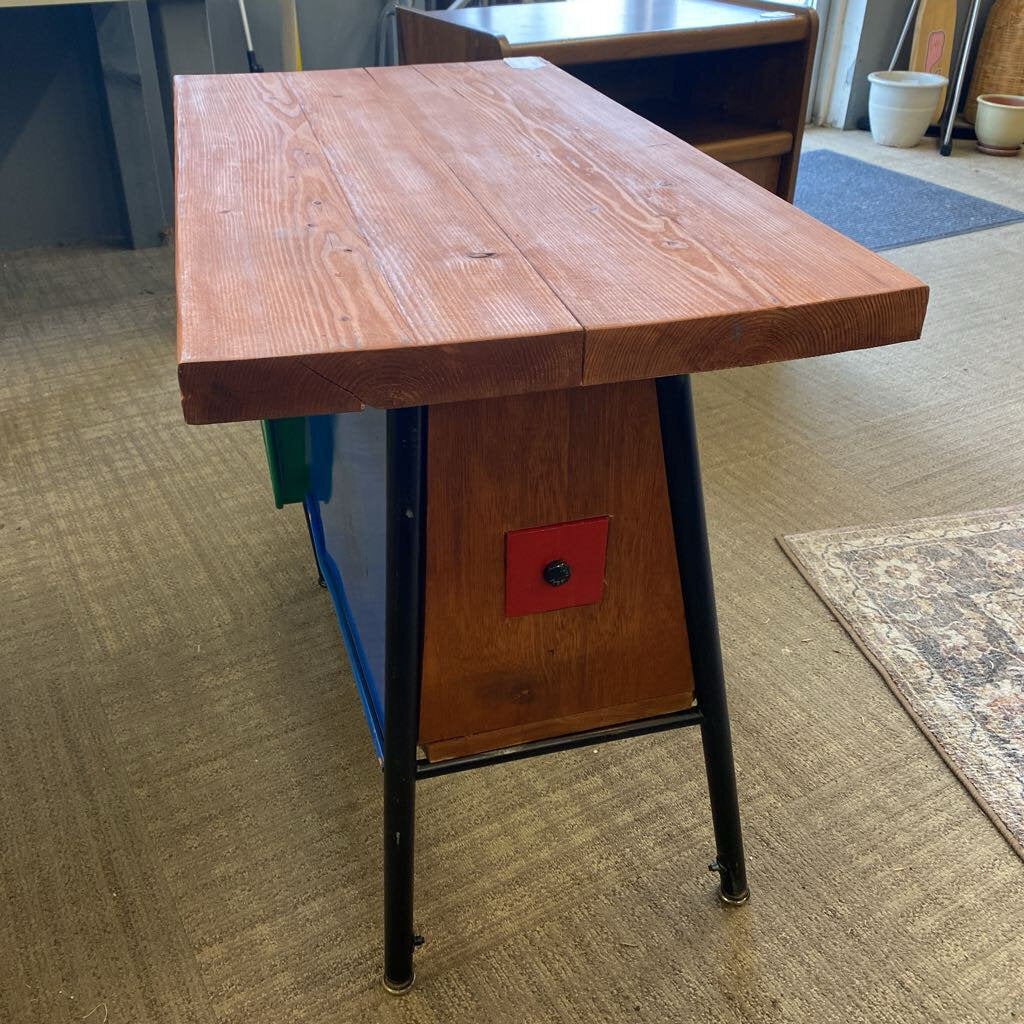Wooden table with black metal legs on a carpeted floor