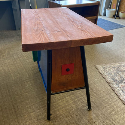 Wooden table with black metal legs on a carpeted floor