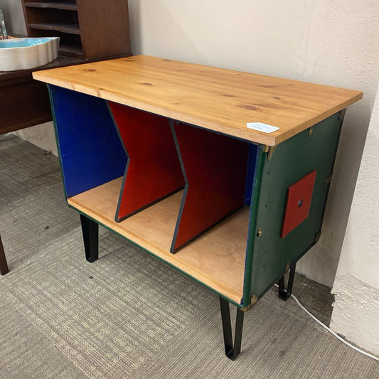 Wooden desk with colorful geometric design on a carpeted floor.