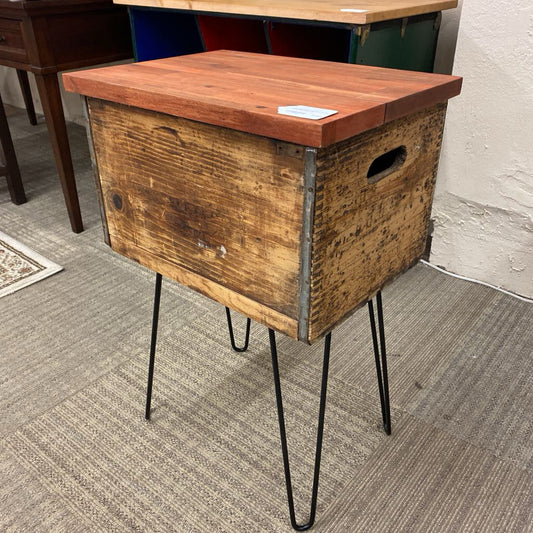 Wooden side table with metal legs on a carpeted floor