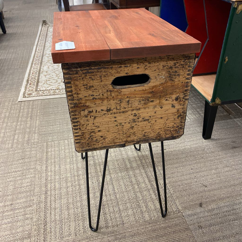 Wooden side table with metal legs on a carpeted floor