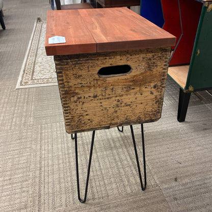 Wooden side table with metal legs on a carpeted floor