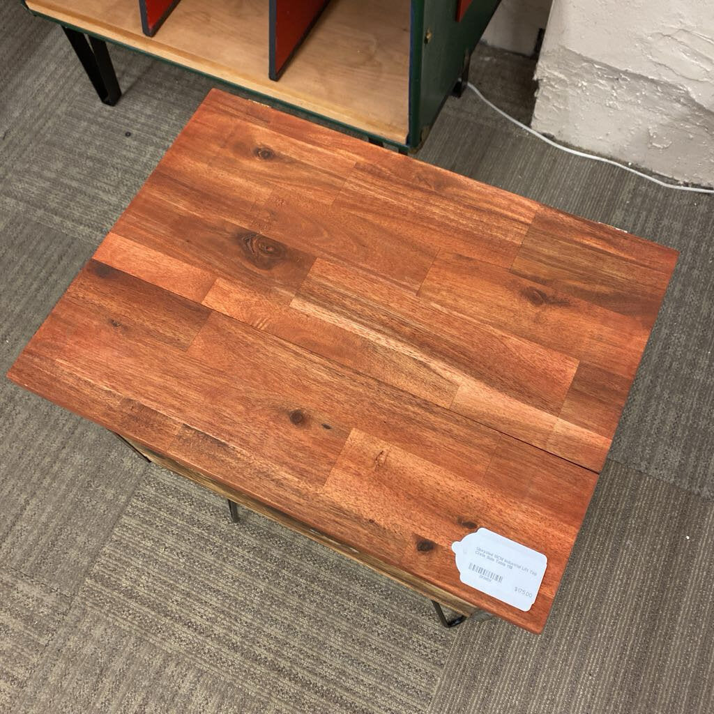 Wooden table on a carpeted floor with a label attached
