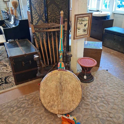 Decorative drum with colorful accents in a room with furniture and decor items.