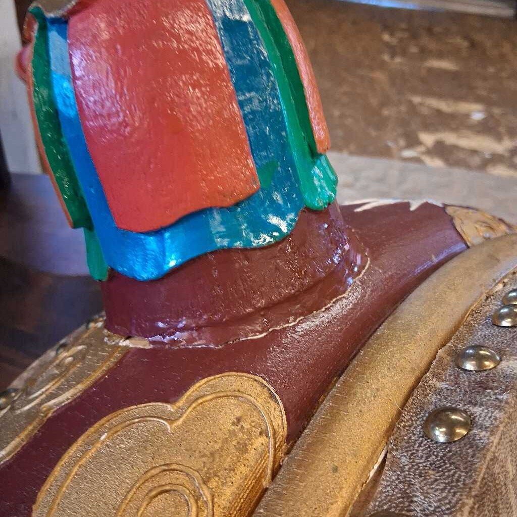 Close-up of a colorful shoe with decorative elements on a wooden surface