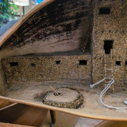 Model of a stone building with a circular feature on a wooden base