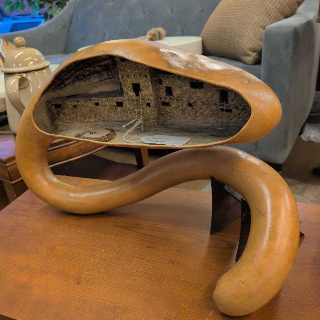 Wooden sculpture resembling a creature on a wooden surface with a blurred background