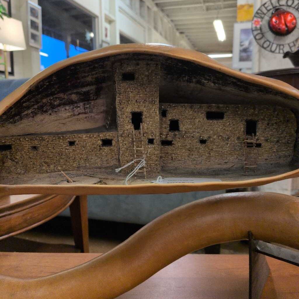 Model of a brick building inside a wooden shoe