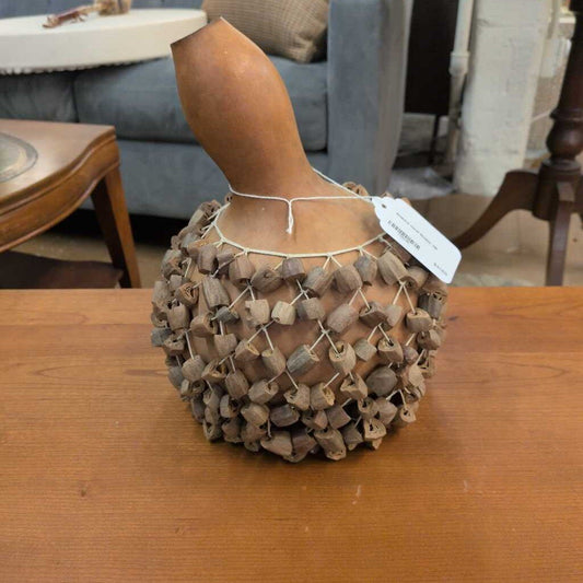 Decorative item resembling a bird with a textured body on a wooden table
