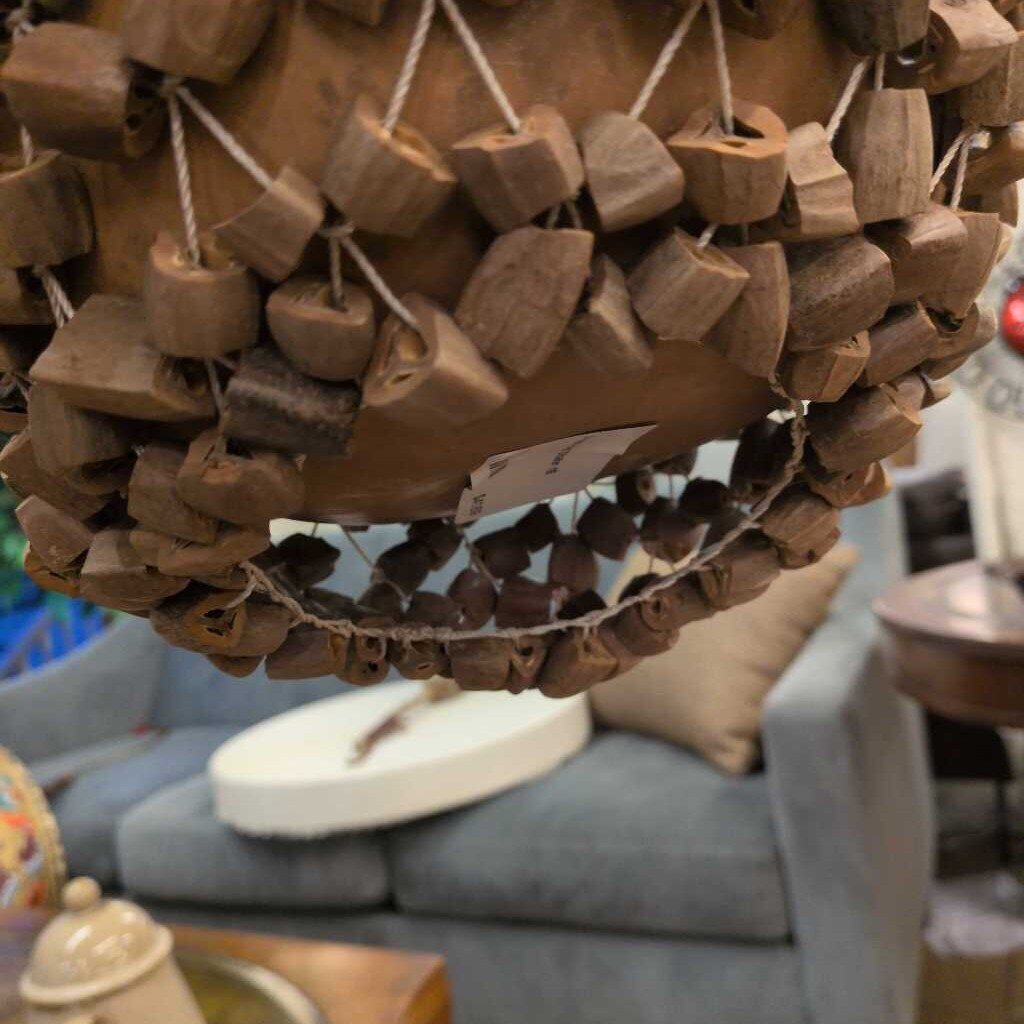 Wooden heart-shaped ornaments hanging on a wall with a blurred indoor setting.