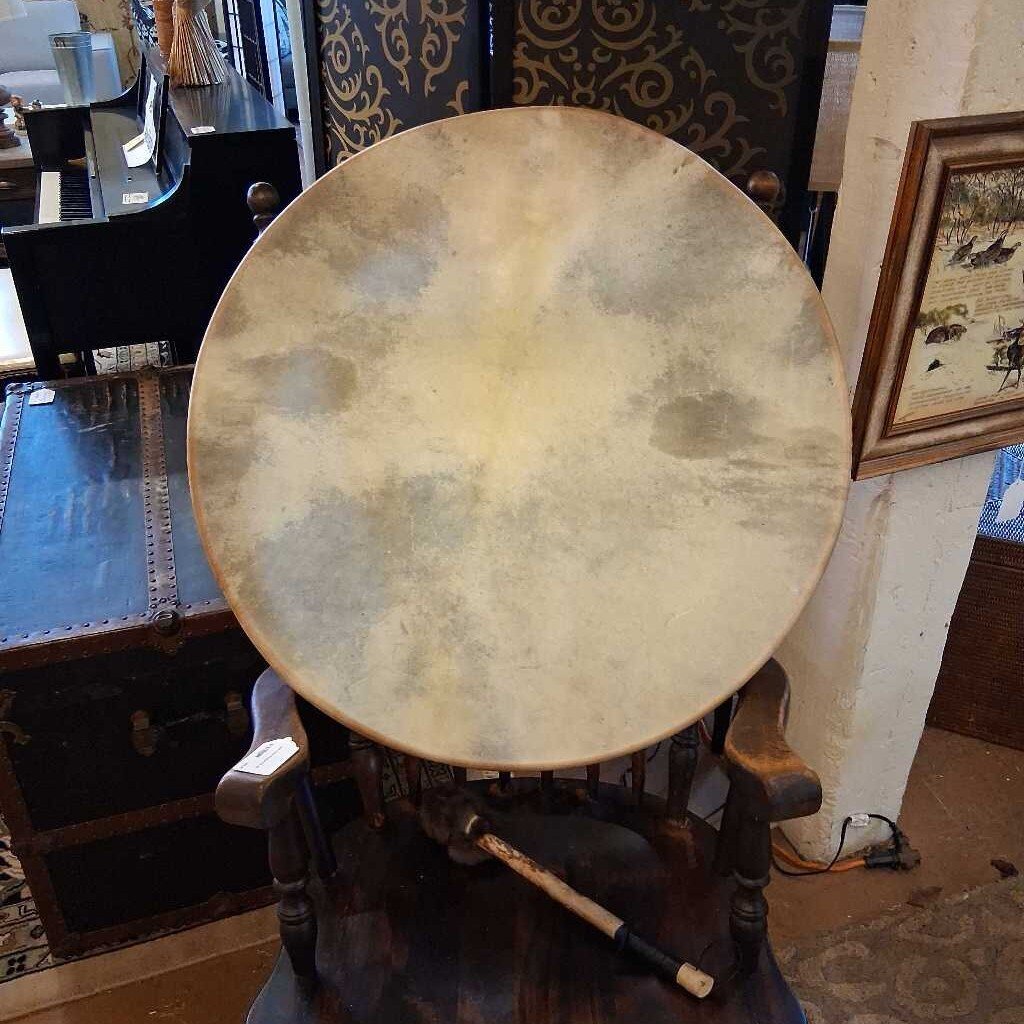 Large round drum on a stand in an indoor setting with decorative elements.