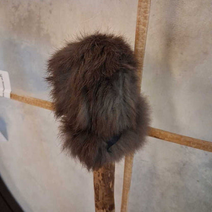 Furry object on a stand against a textured wall