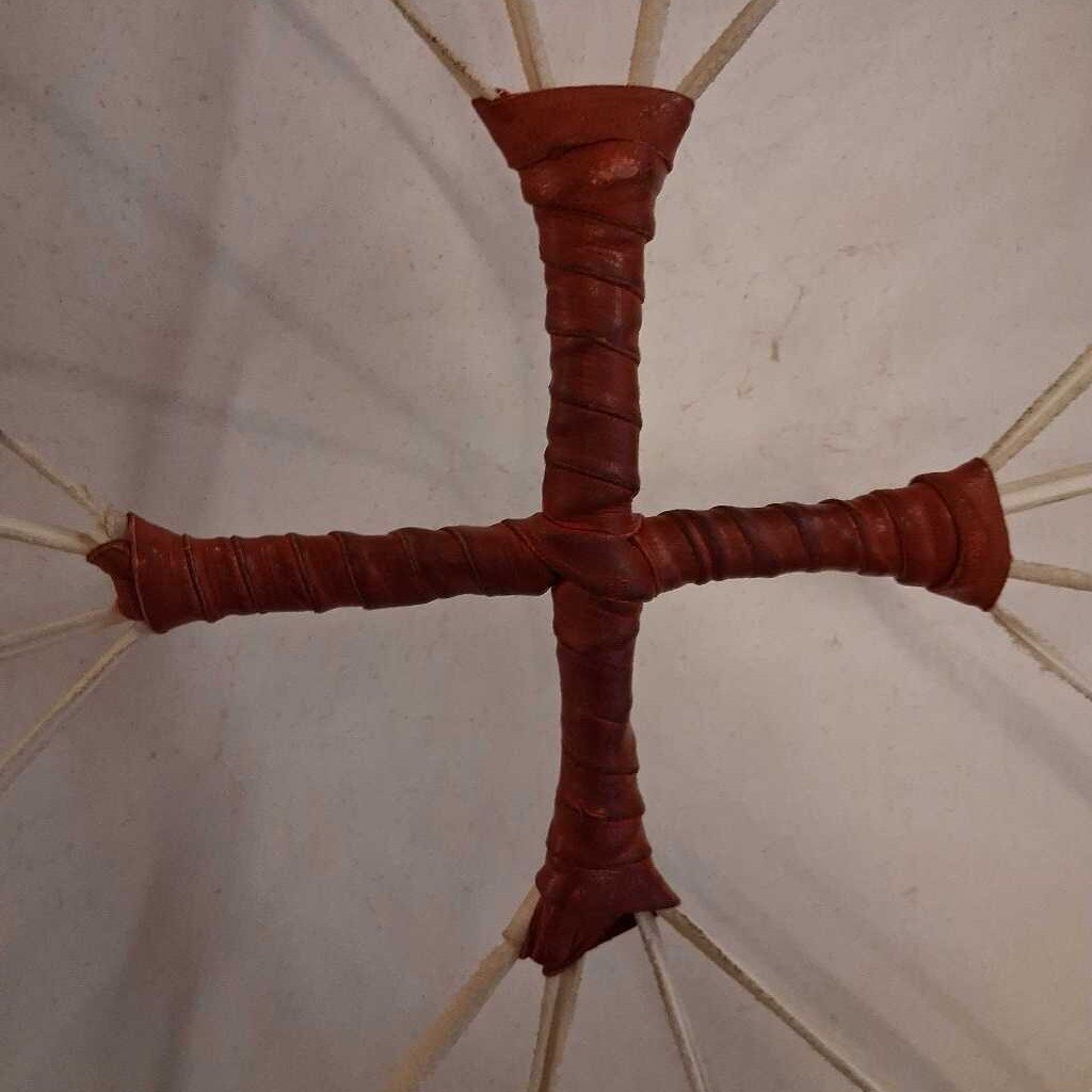 Close-up of a red cross-shaped object with a beige background