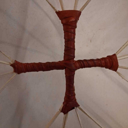 Close-up of a red cross-shaped object with a beige background